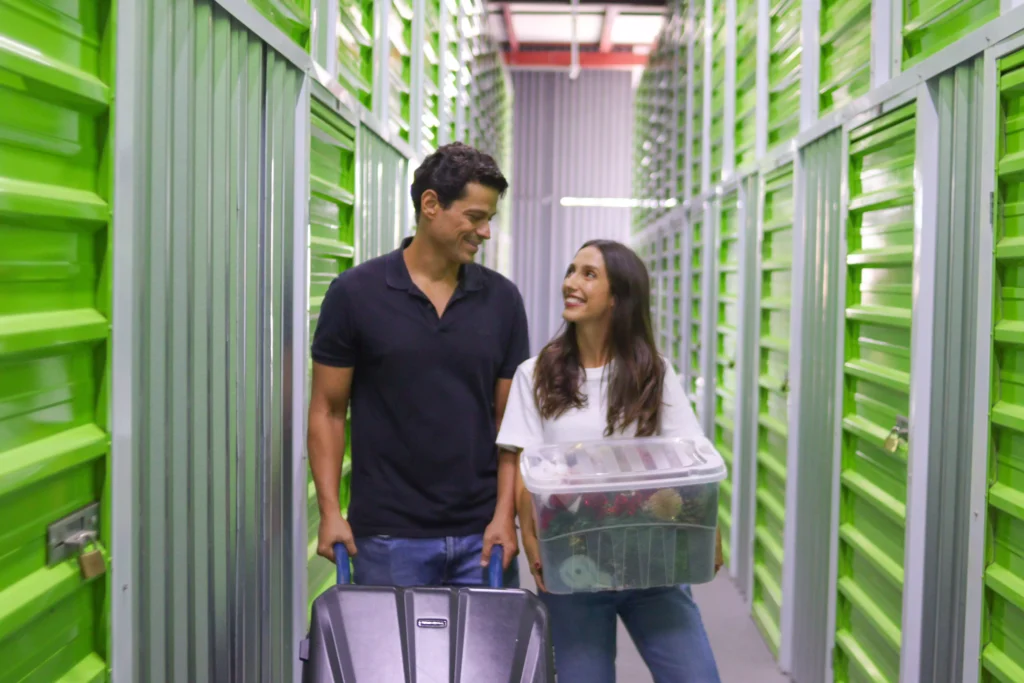 duas pessoas em um corredor de uma unidade de armazenamento com boxes na cor verde